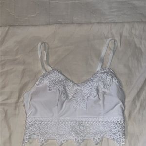 Cropped white lace tank top. Adjustable straps and cups in cleavage area.